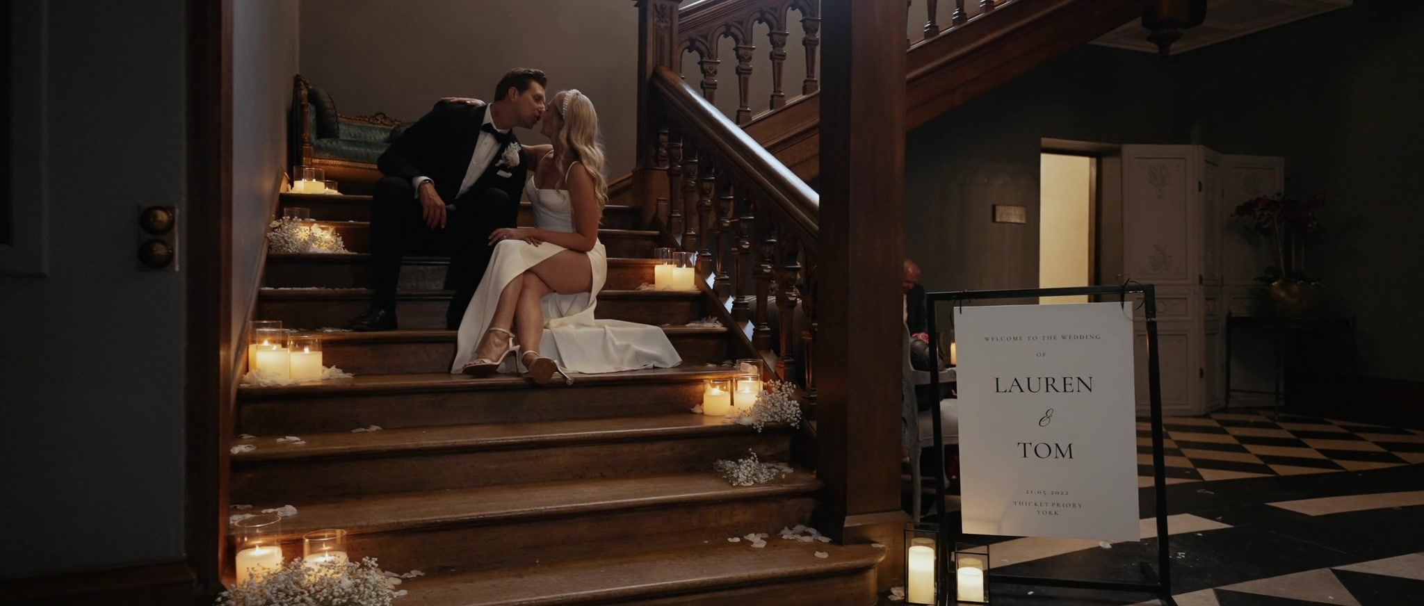 Lauren and Tom kiss on the staircase, the steps lined with candles